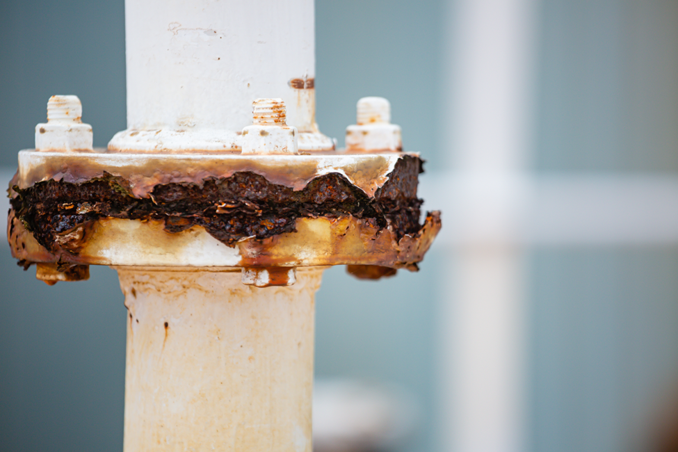Close-up of a corroded industrial tube joint section